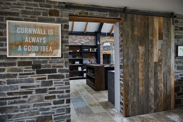 Reclaimed internal sliding barn door against stone wall