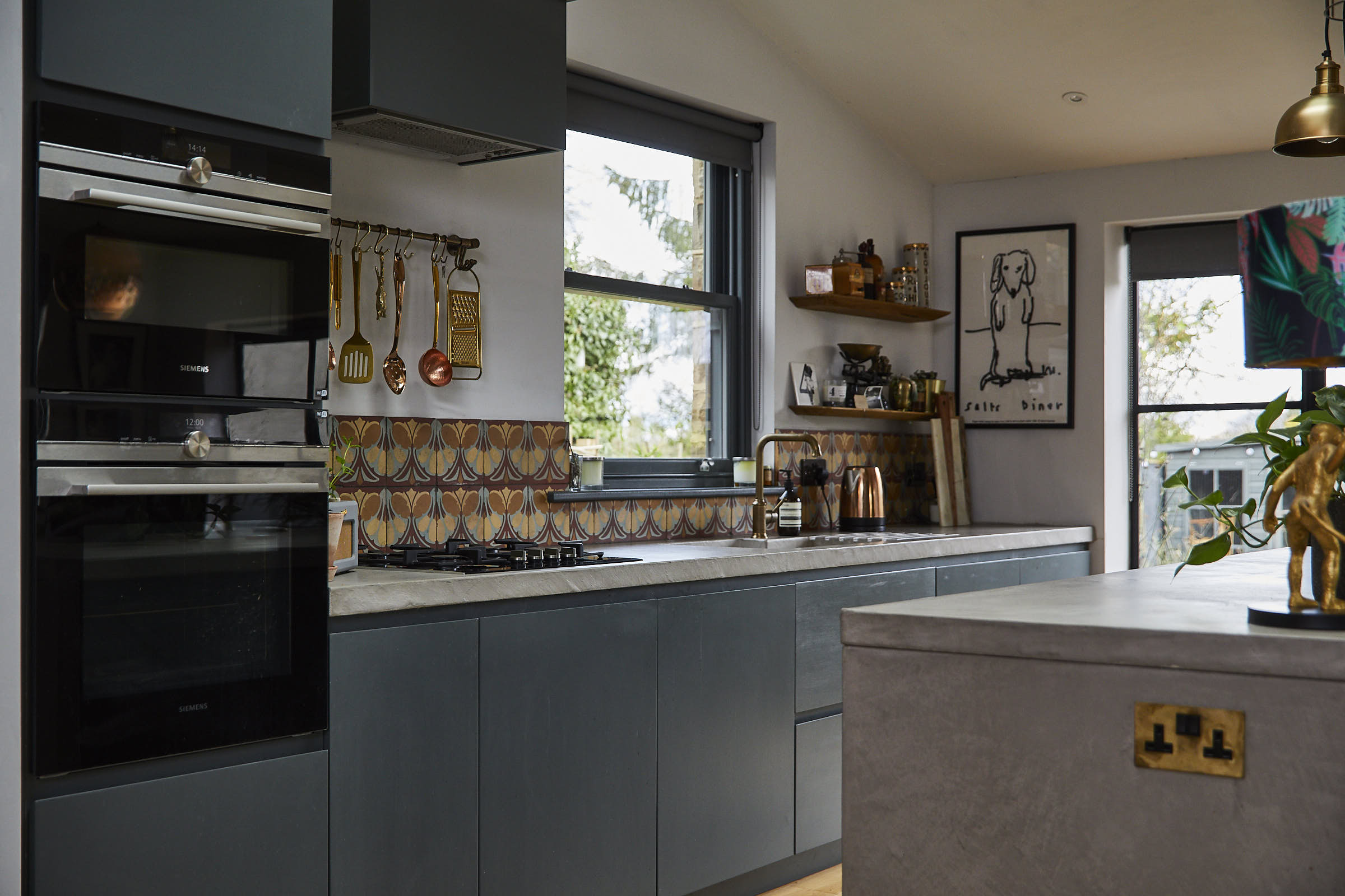 Bespoke painted kitchen with solid concrete worktops and colourful shell tiles