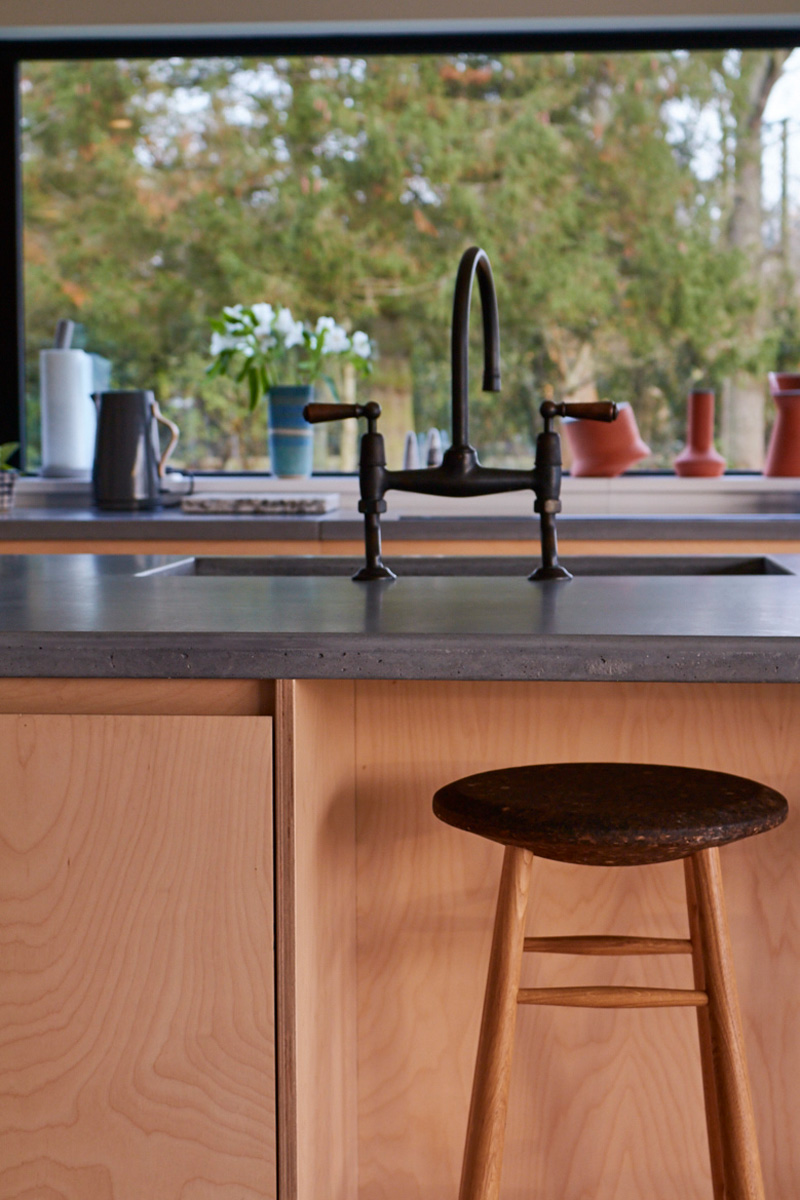 Integrated bin in island with oak bar stool