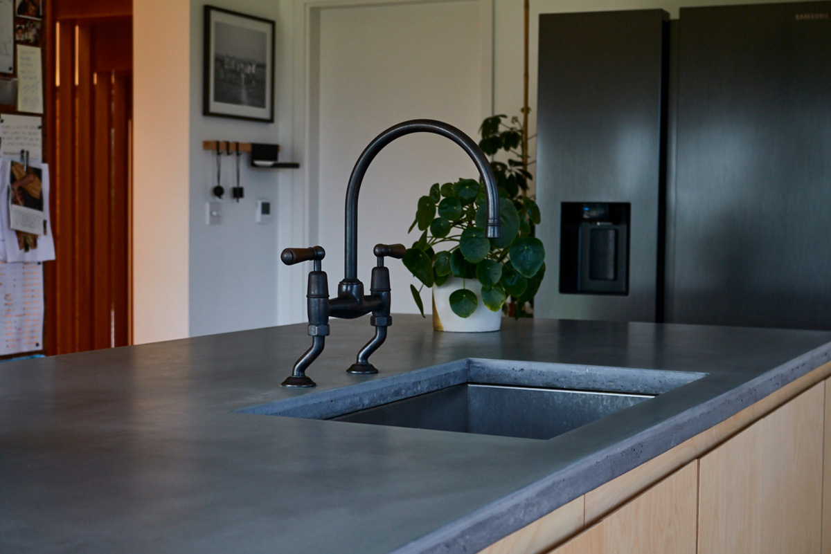 Antique transitional tap sits on solid concrete worktops