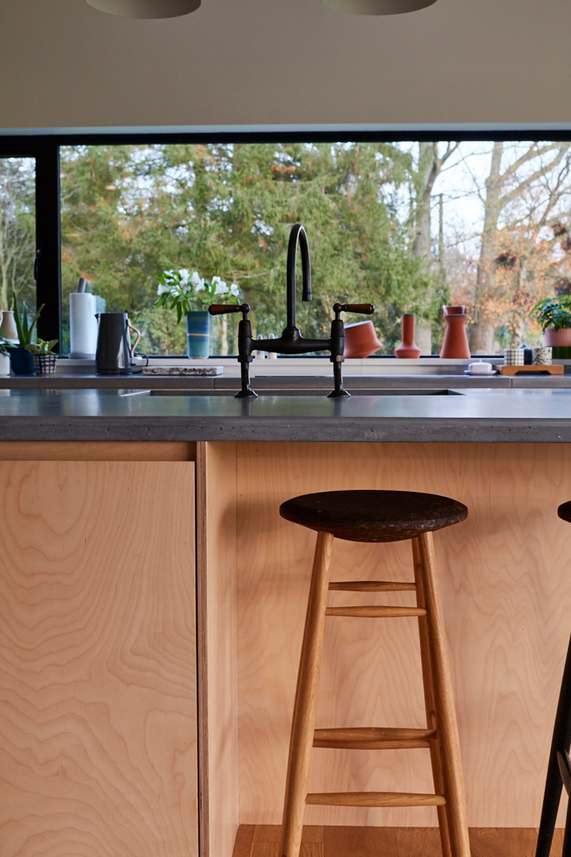 Bespoke birch plywood kitchen units and custom concrete grey worktops make island