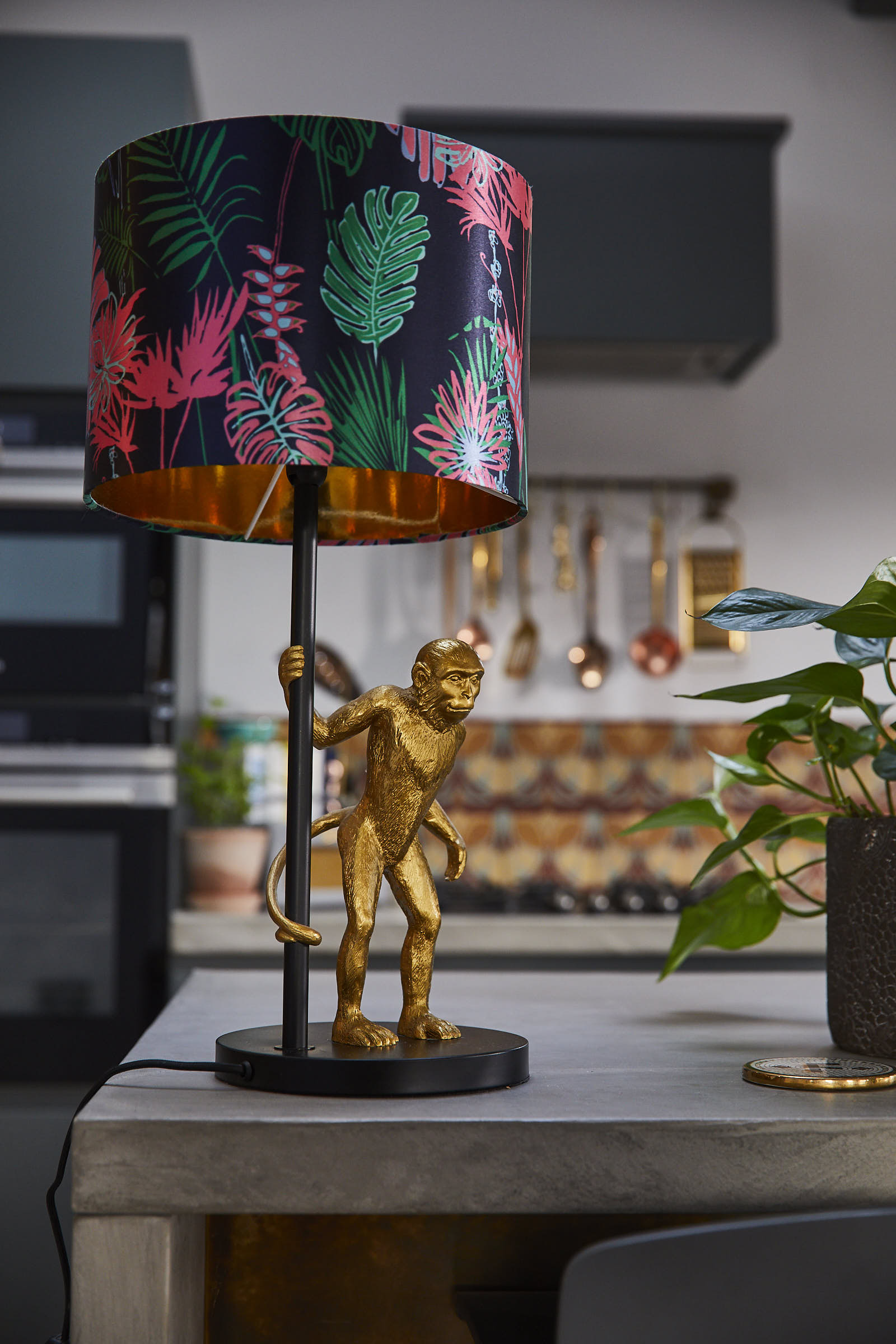 Gold monkey lamp holding colourful pink shade
