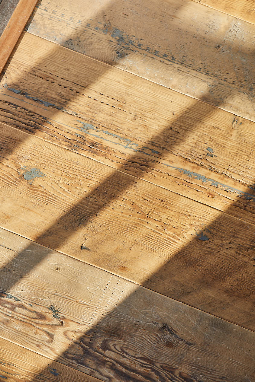 Shadows cast on raw reclaimed mill pine floor boards