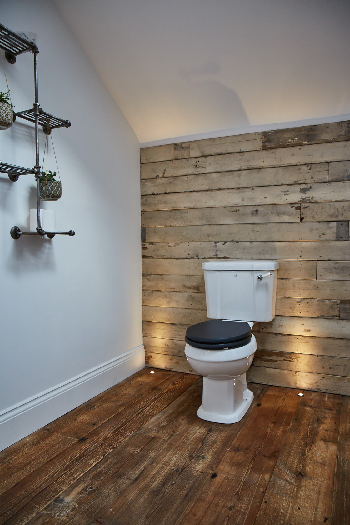 White rustic cladding behind traditional toilet