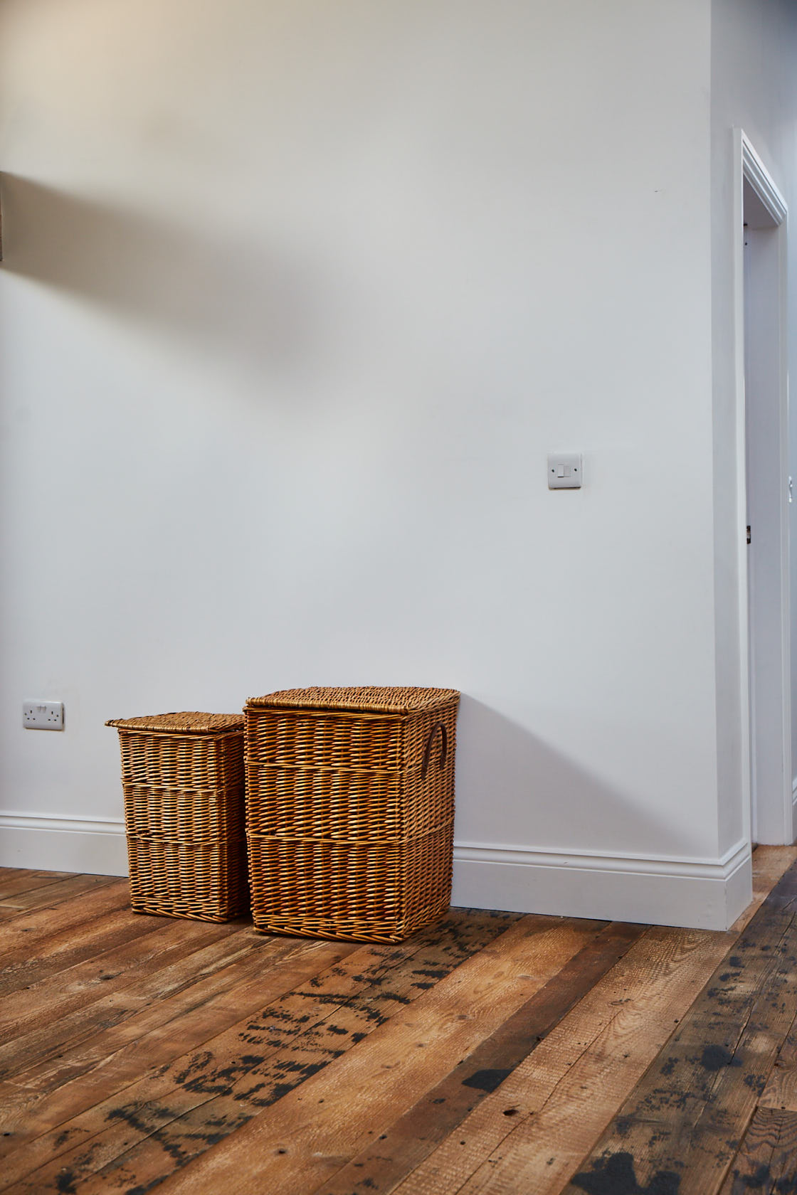 Baskets sit on reclaimed barn brown wood flooring