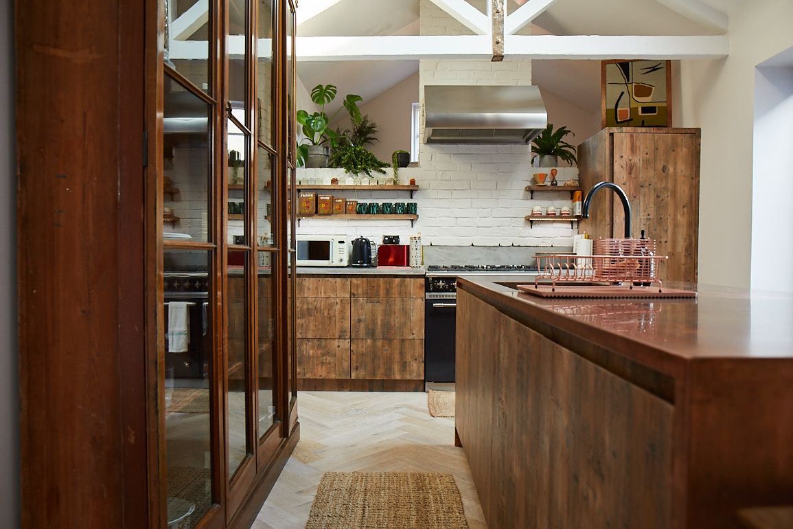 Original glass unit in open plan bespoke kitchen with copper worktops and reclaimed engineered pine units