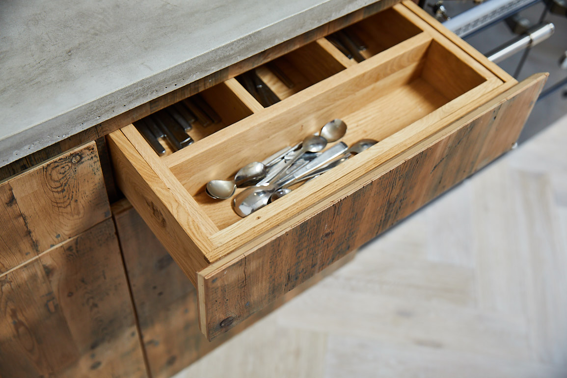 Solid oak utensil inset in reclaimed pan drawers with concrete worktop