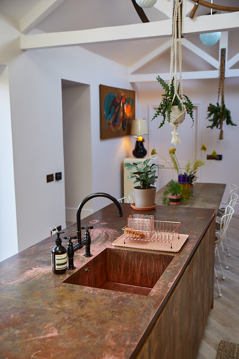 Copper worktop with seamless single sink and black mixer tap