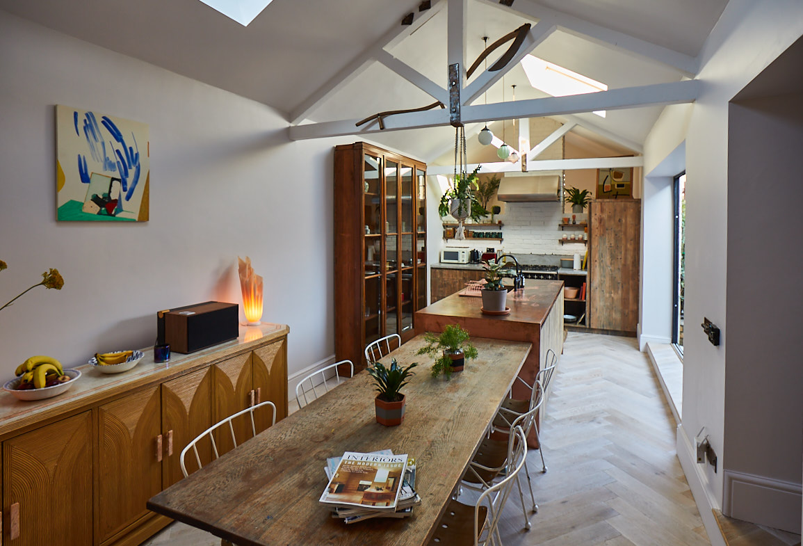 Open plan kitchen and dining with reclaimed table and bespoke copper metal island