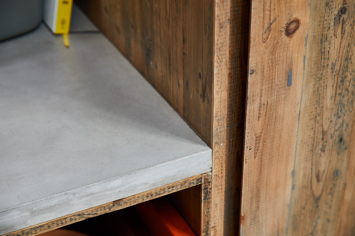 Solid concrete kitchen worktop hits in to reclaimed pine larder unit