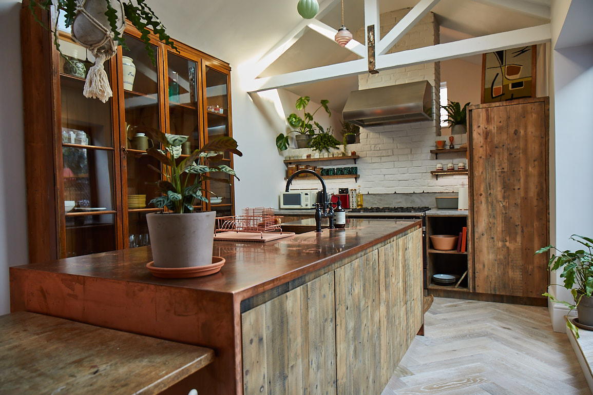 Reclaimed rustic bespoke open plan kitchen island with copper worktop and parquet oak flooring