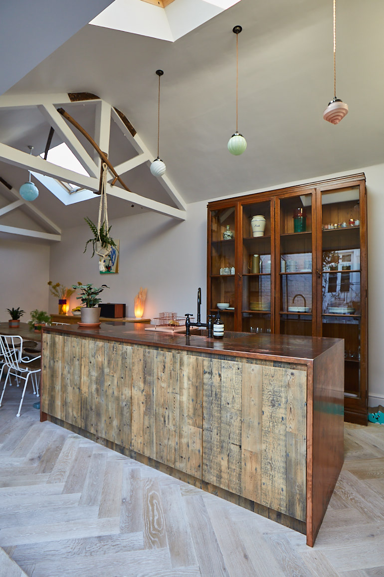 Bespoke kitchen island in front of original glass cabinet