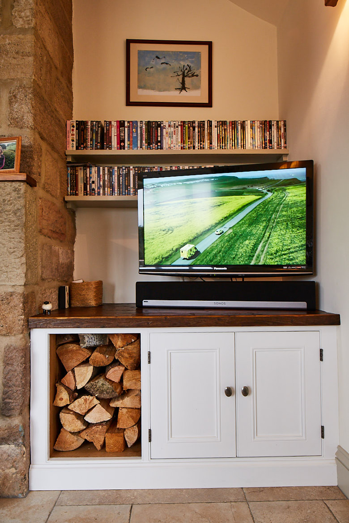 Full fited tv unit with log storage fitten in to farmhouse alcove