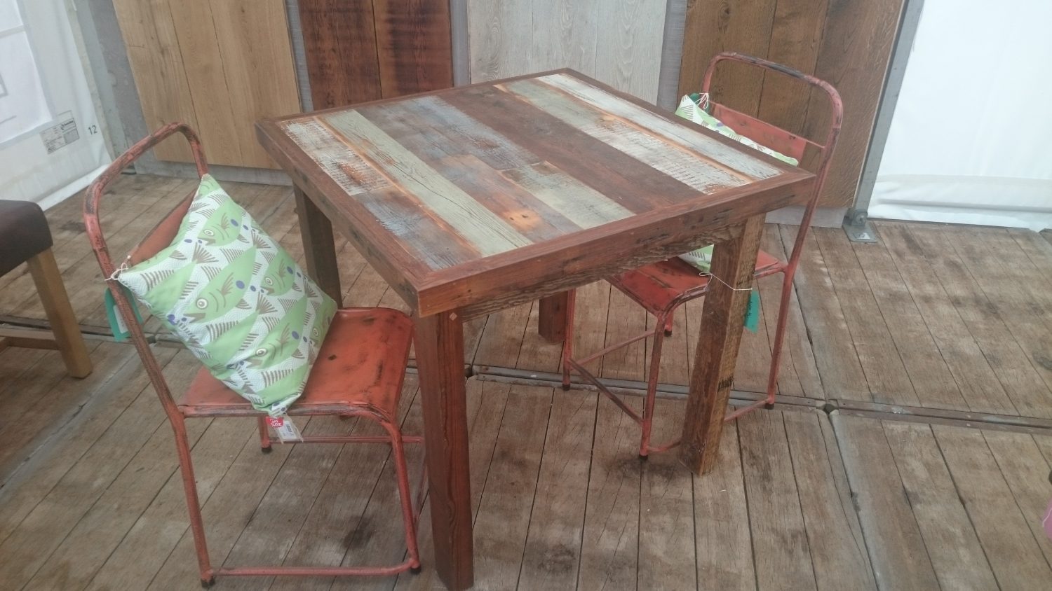 Square rustic bistro table with red metal industrial chairs