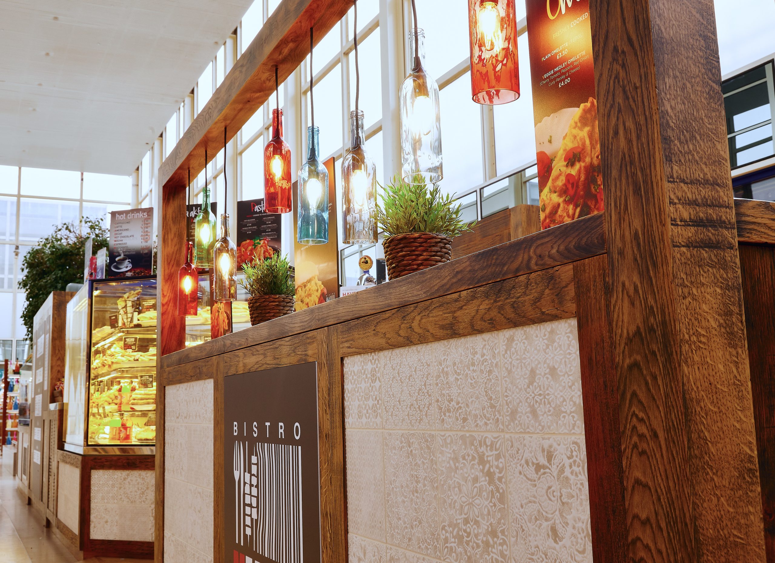 Colourful wine bottle lights hang above rustic bistro seating area