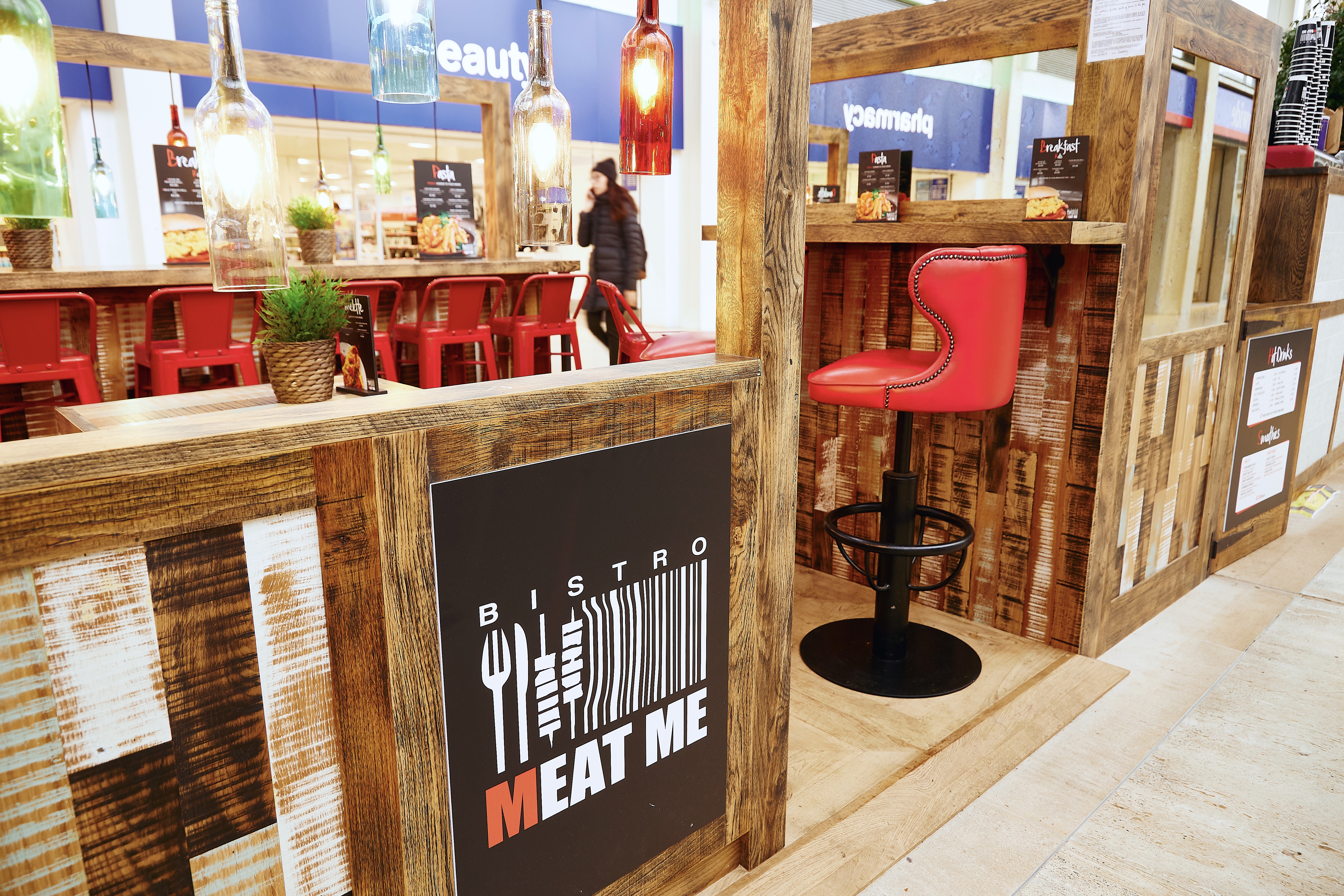 Meat Me Bistro branding with rustic wood surround and red leather bar stool