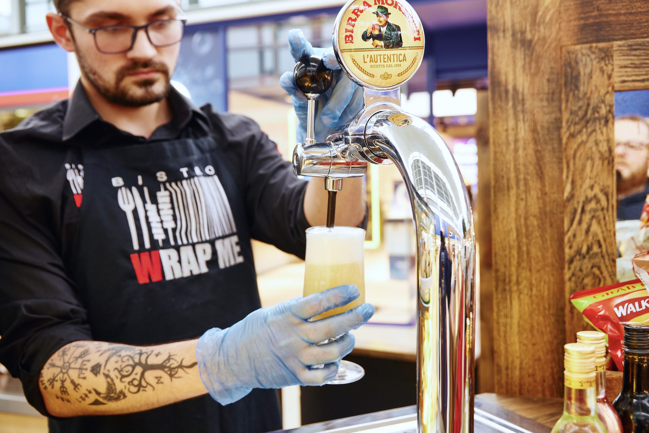 Bistro worker pours half pint of moretti