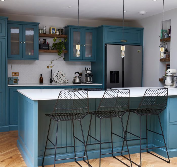 Bespoke blue green kitchen with black metal bar stools finished with brass buster + punch hardware