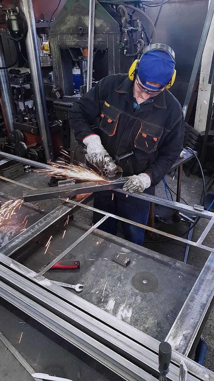 Welder sanding bespoke metal doors