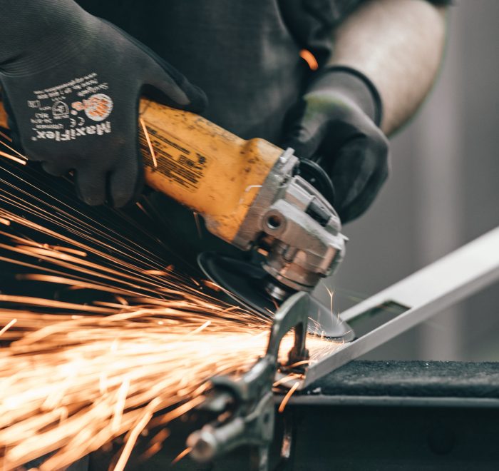 Sparks fly from bespoke metal doors while being sanded