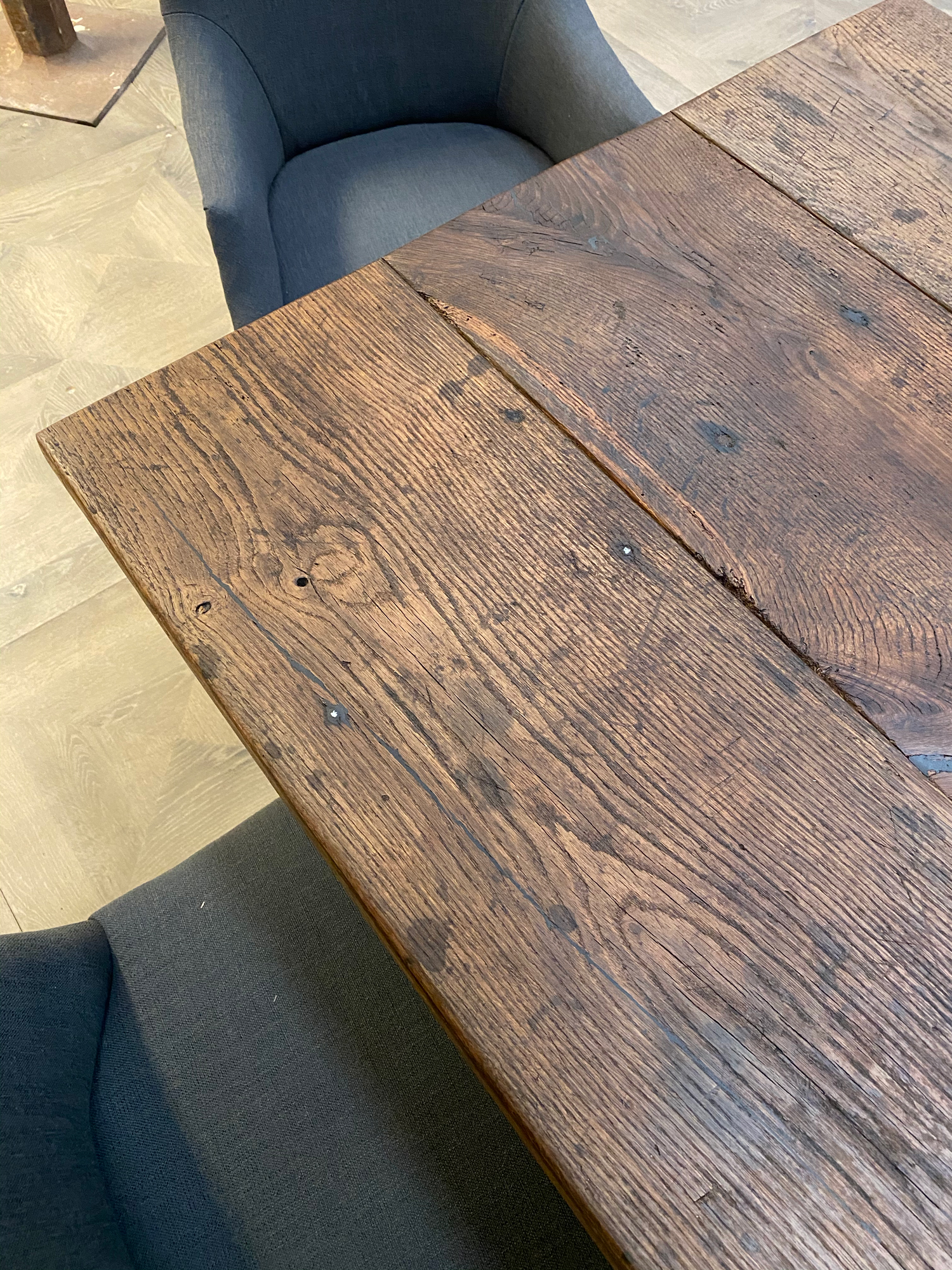 Blue upholstered dining chairs under reclaimed oak dining table