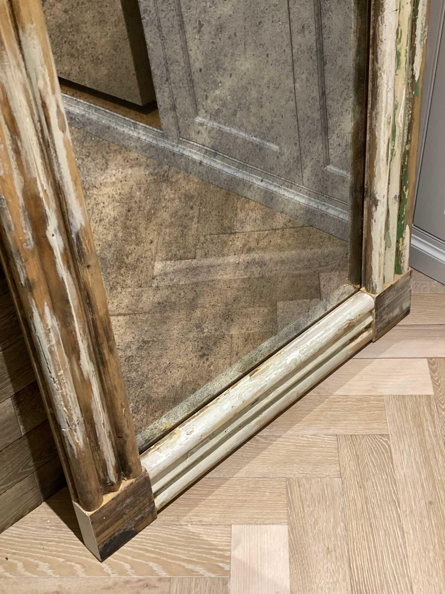 Antique mirror reflects parquet flooring