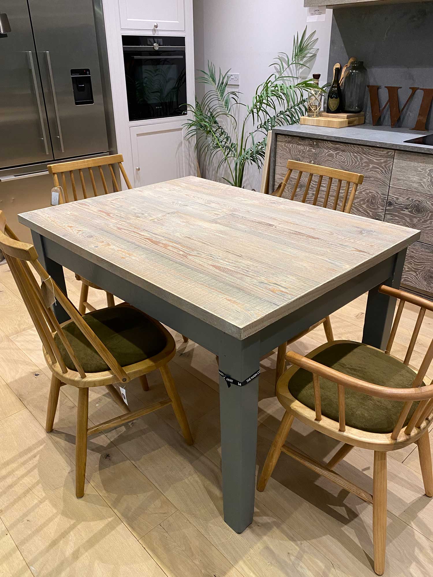 Small whitewash table with painted base in kitchen showroom