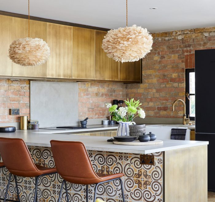 Reclaimed tiled metal kitchen with brown leather barstools