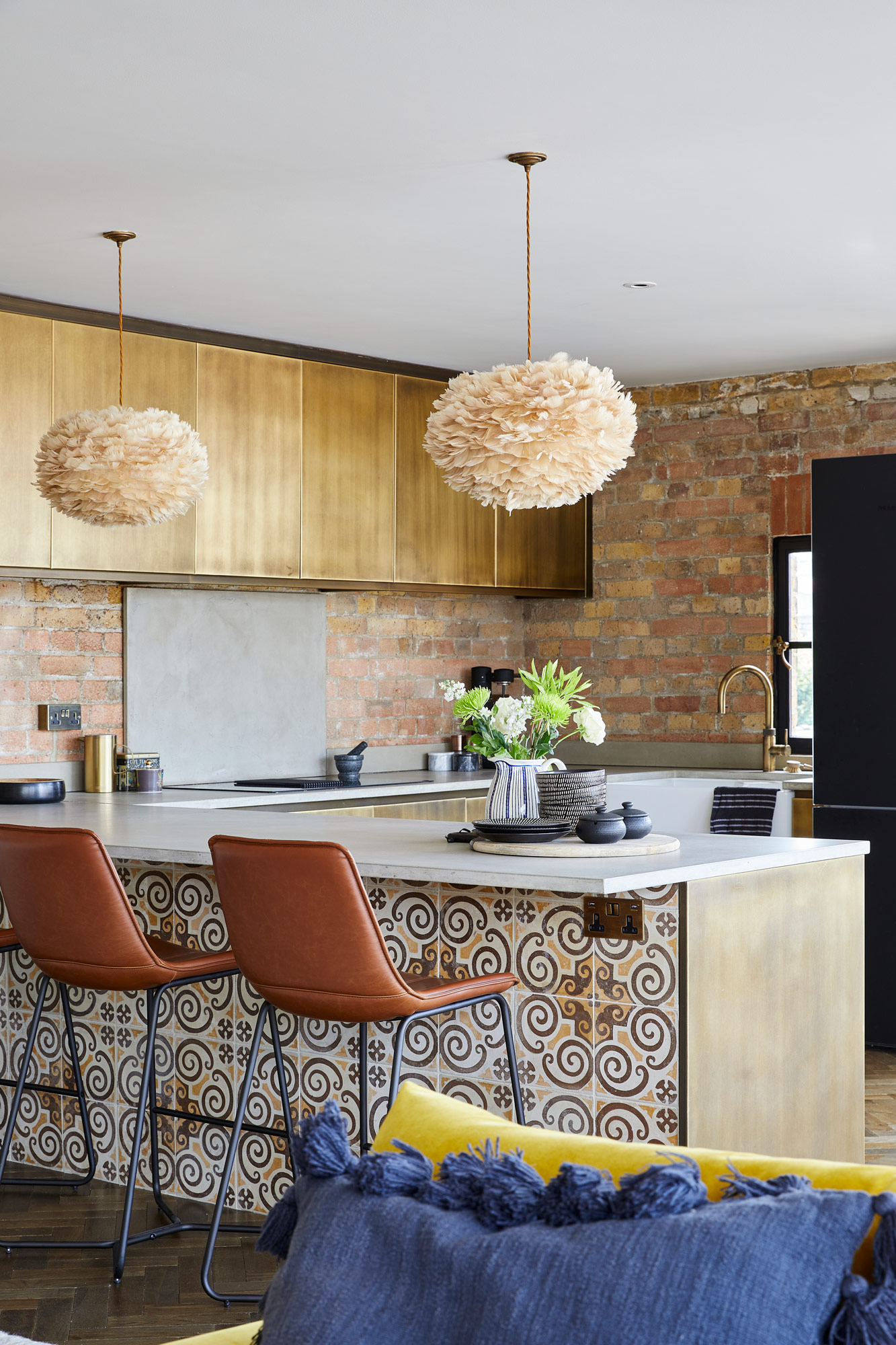 Reclaimed tiled metal kitchen with brown leather barstools