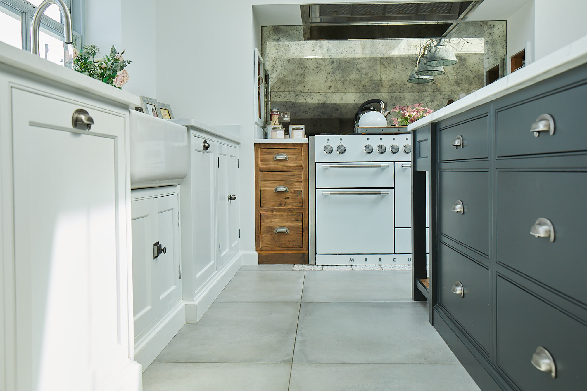 Rustic pan drawers with white quartz worktop and antique mirror backsplash