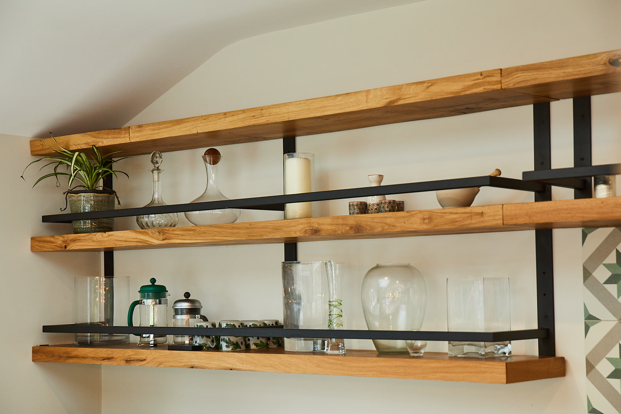 Open chunky oak shelves with glass vases and plants displayed