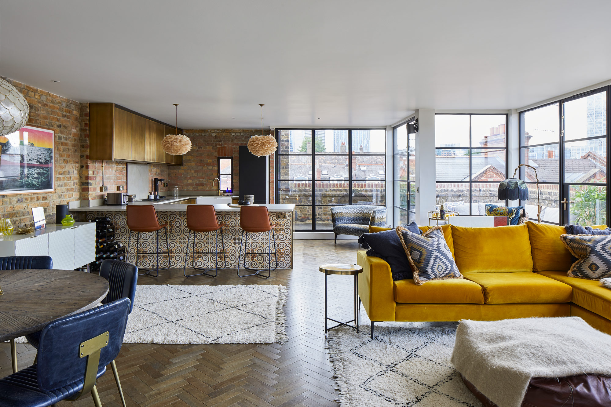 Open plan London flat with yellow sofa and metal kitchen
