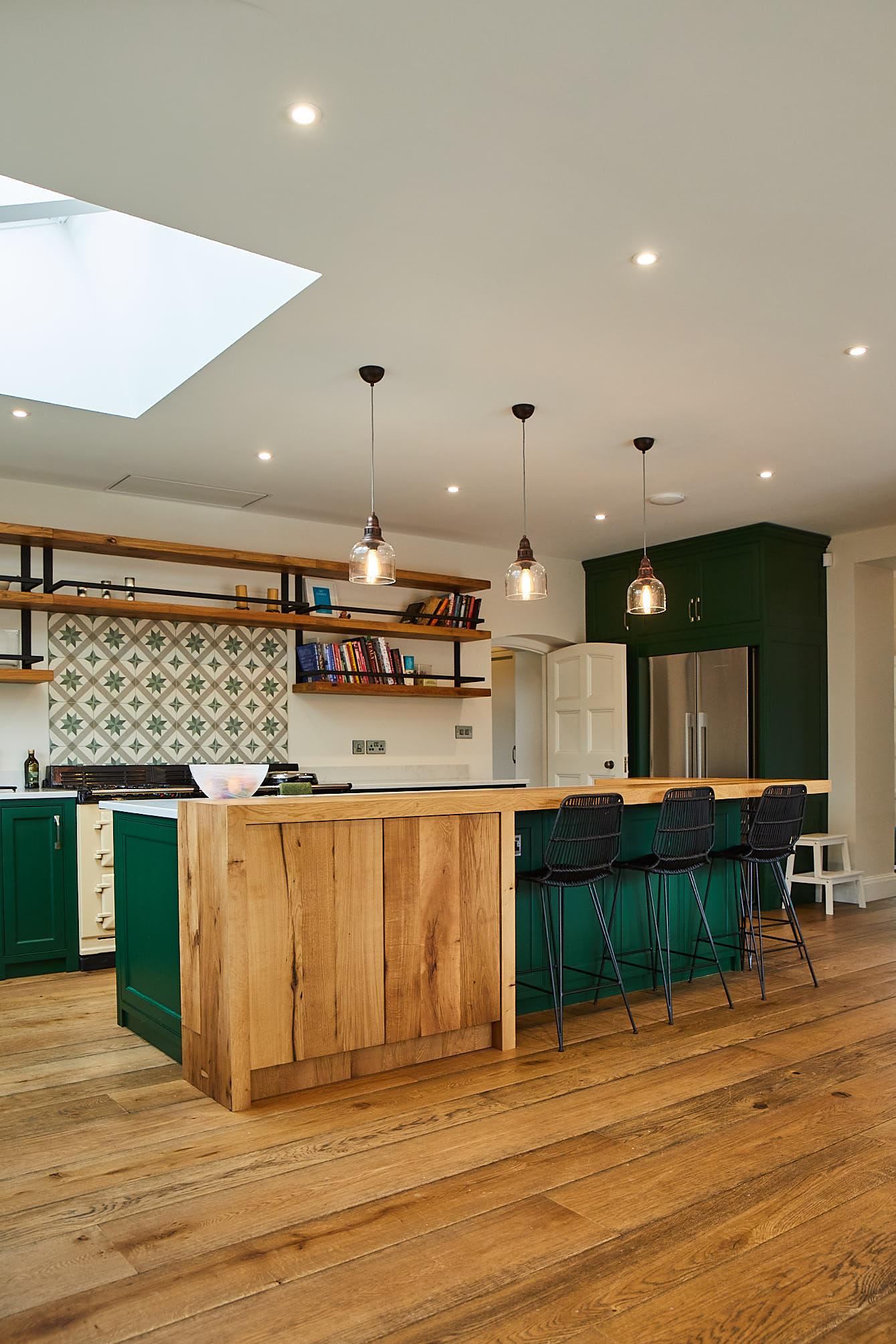 Oak kitchen breakfast bar with black stools and Little Greene painted cabinets