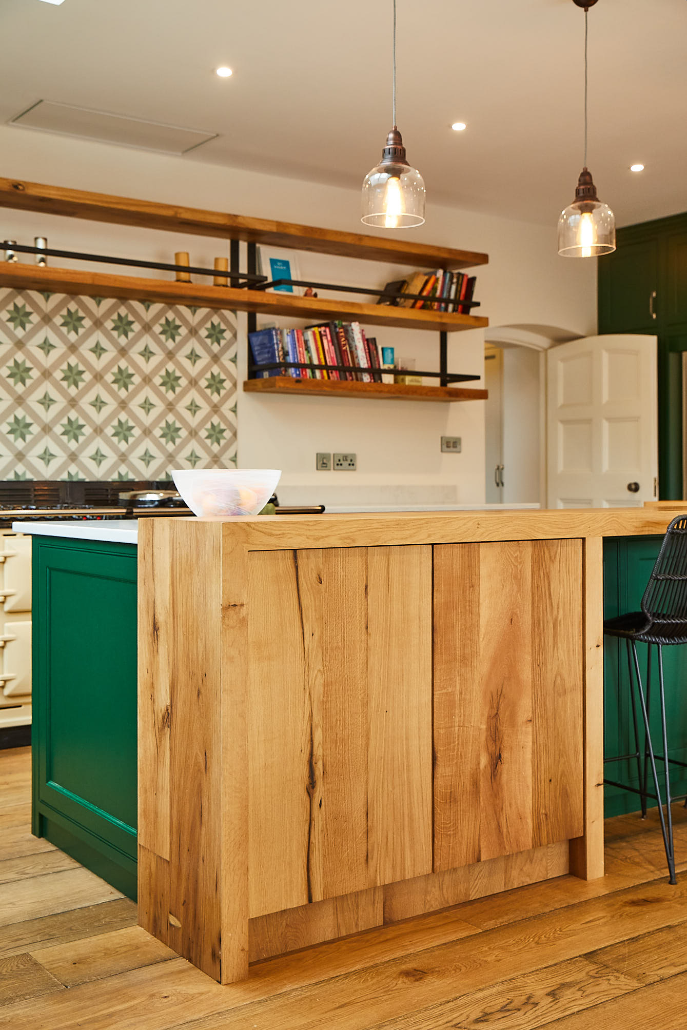 Clean oak wrap around breakfast bar with green kitchen cabinets