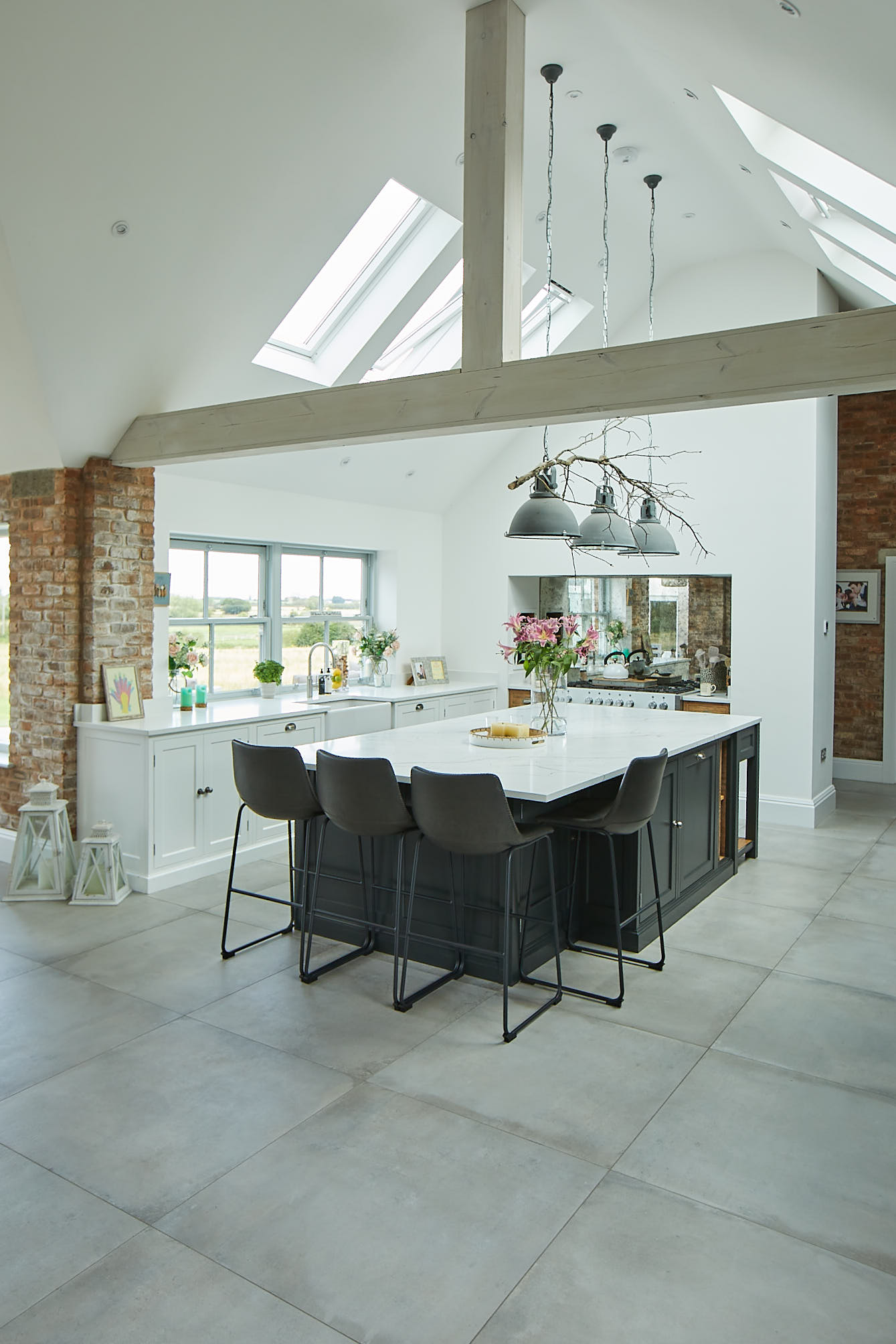 Large vaulted ceiling in open plan kitchen diner with white and black painted cabinets