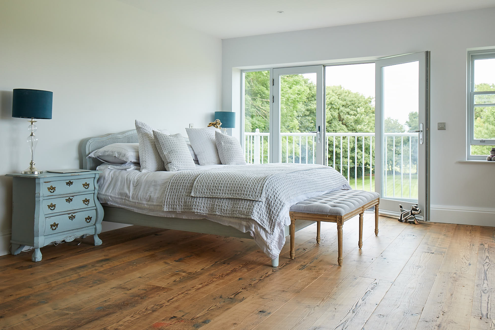 French blue bed and bedside table with rustic reclaimed engineered original douglas fir pine flooring