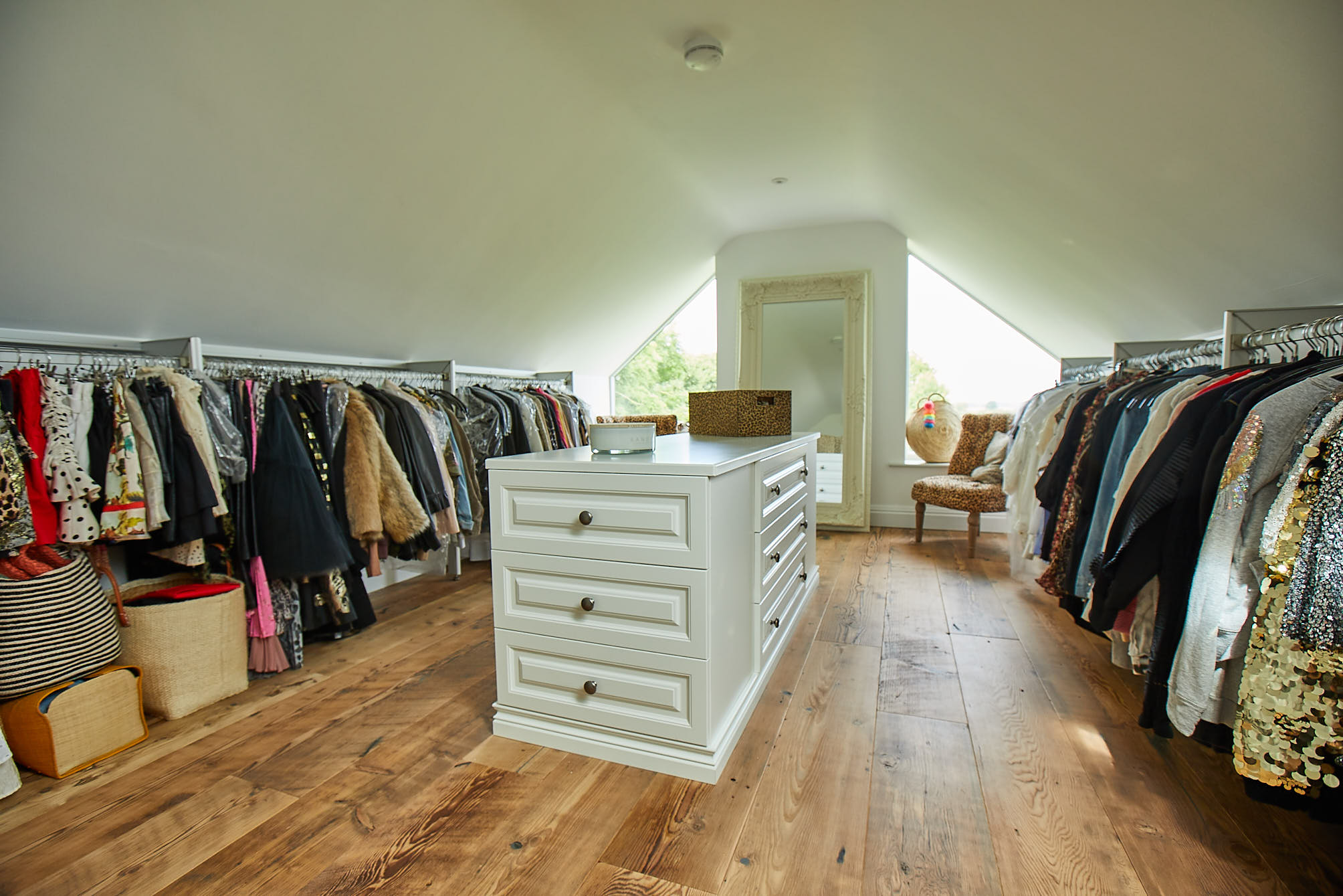 Walk in wardrobe with painted drawers and reclaimed flooring