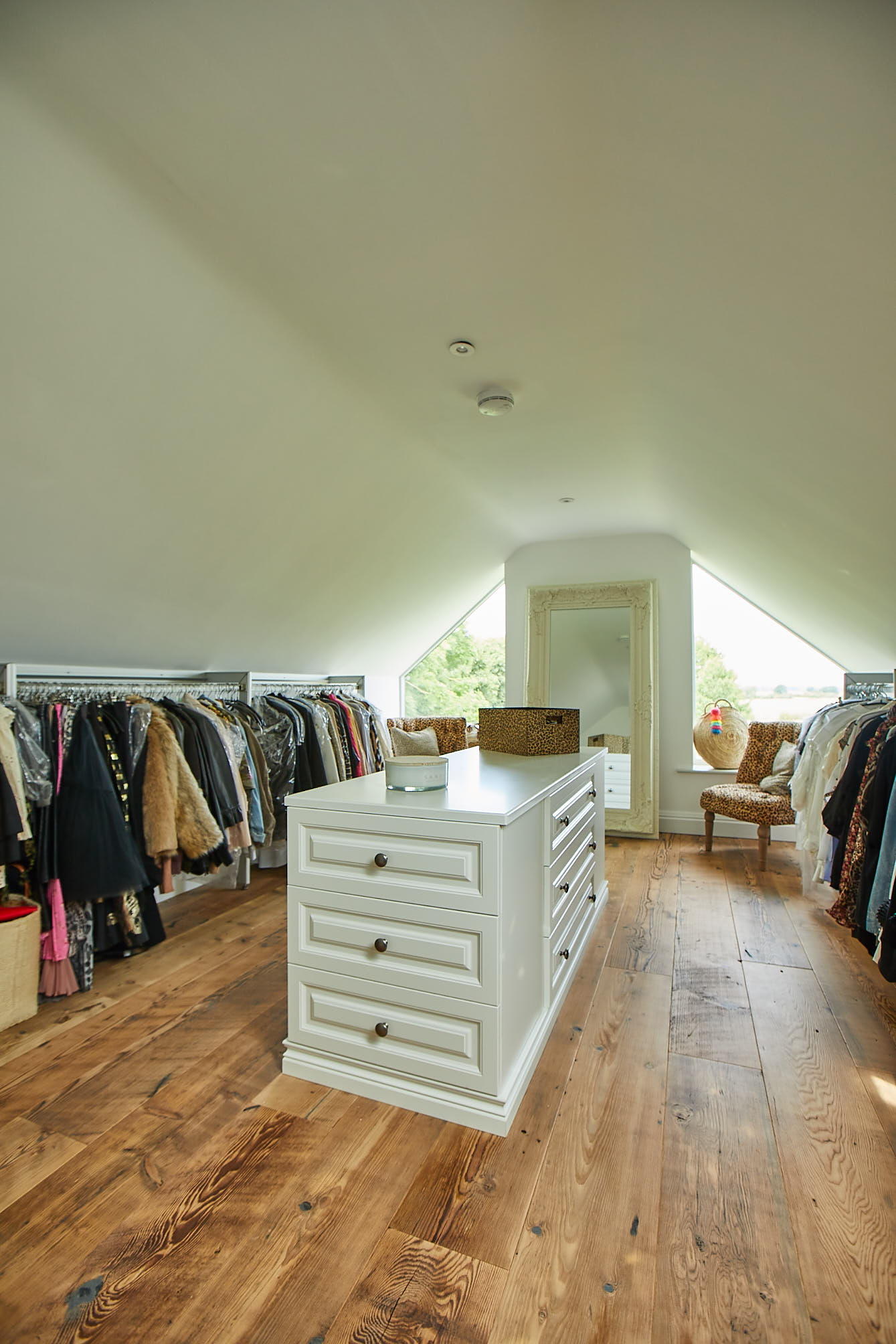 Reclaimed floorboards flow in to walk in wardrobe