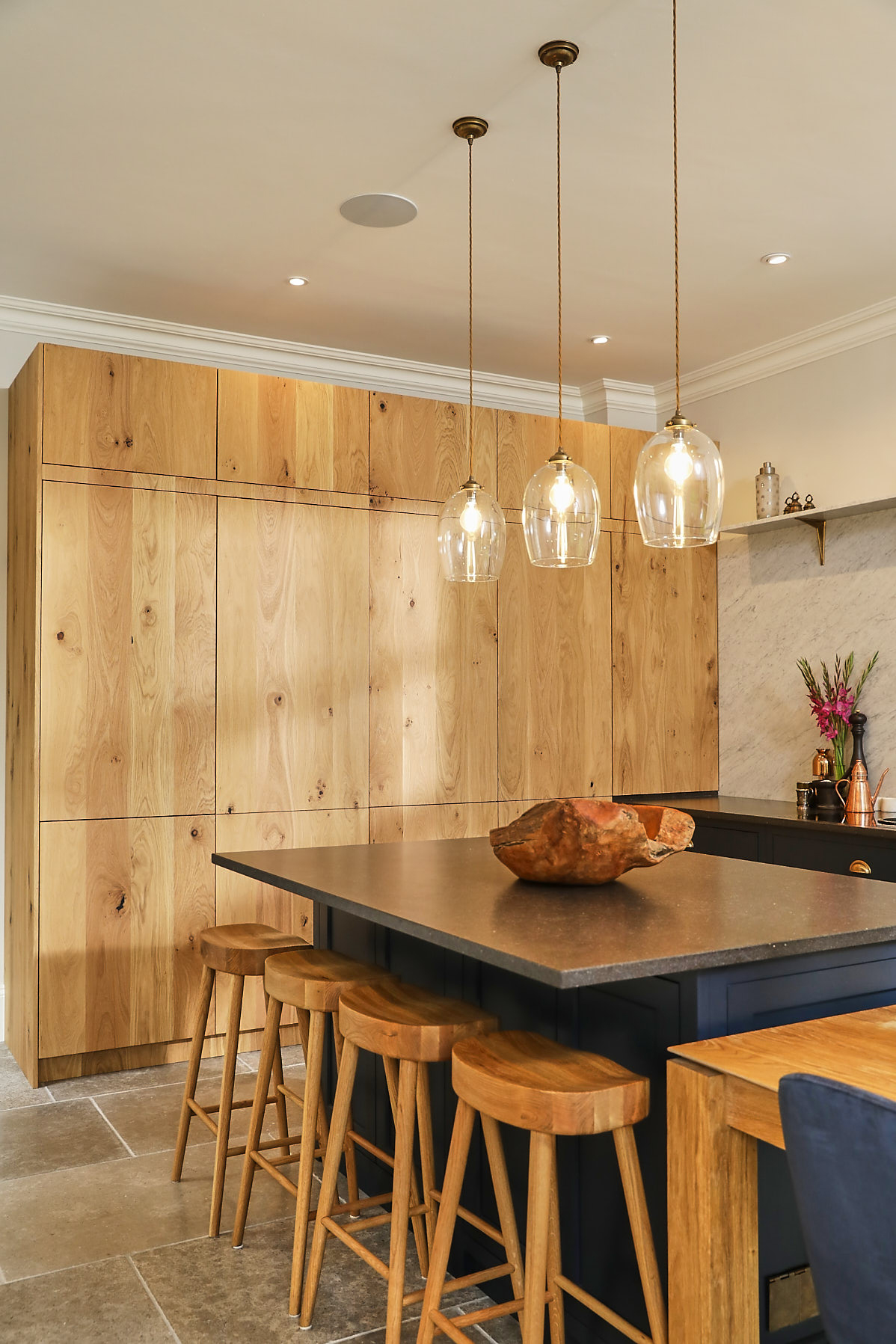 Glass pendant lights above kitchen island and oak farmhouse breakfast bar stools