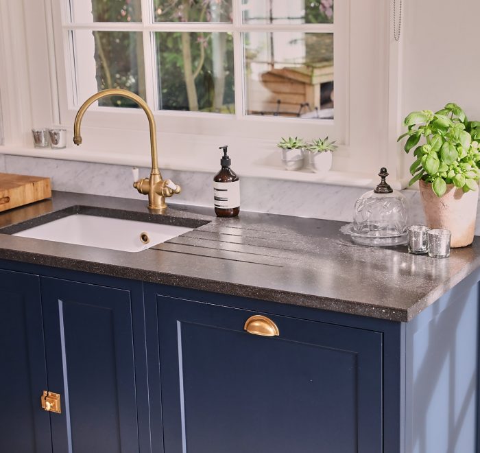 Integrated dishwasher with painted blue in-frame cabinets with antique copper cup handle