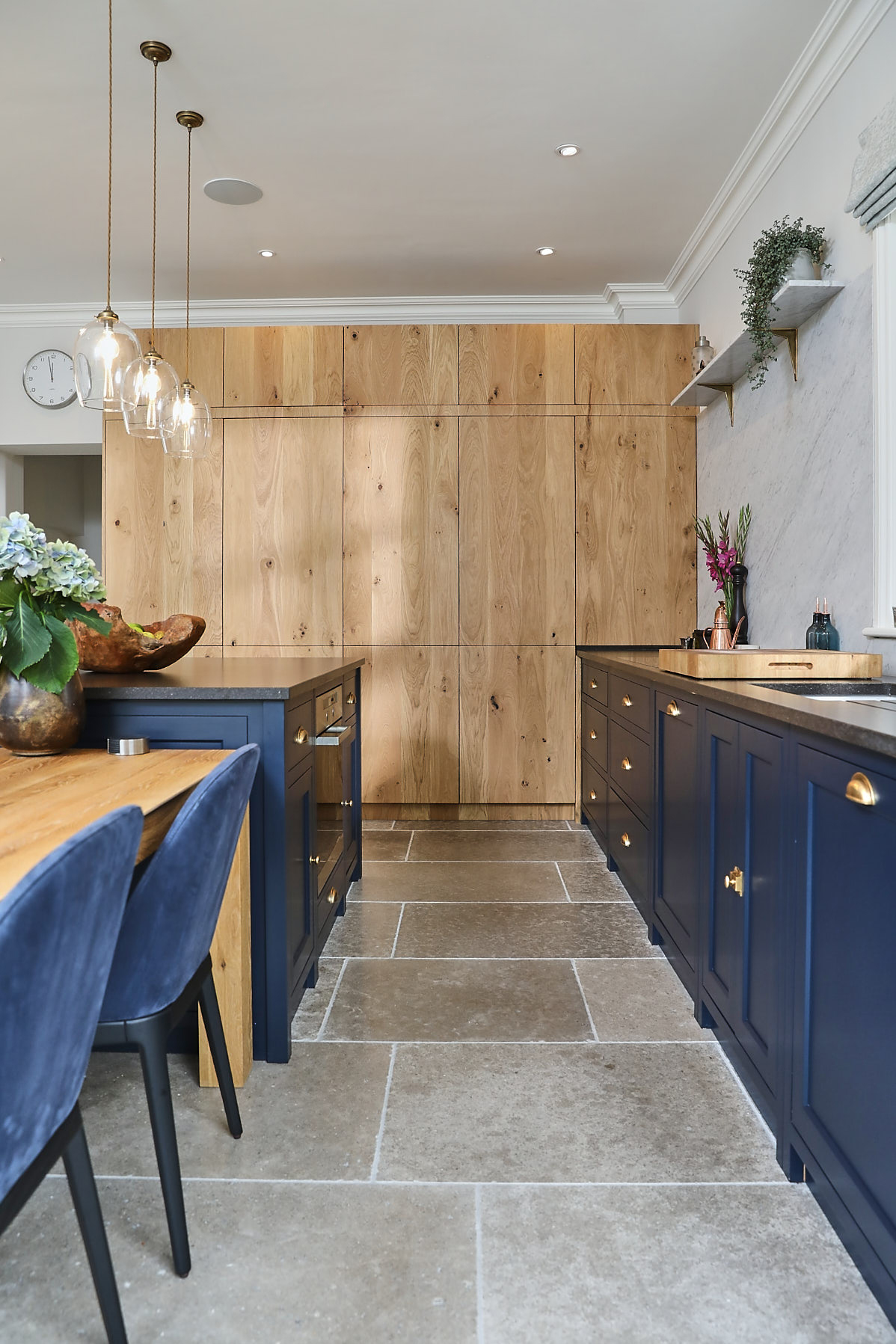 Tall bespoke oak cabinets in blue kitchen