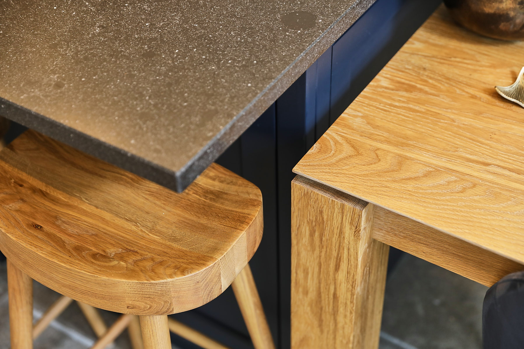 Black granite on kitchen island with oak farmhouse barstool