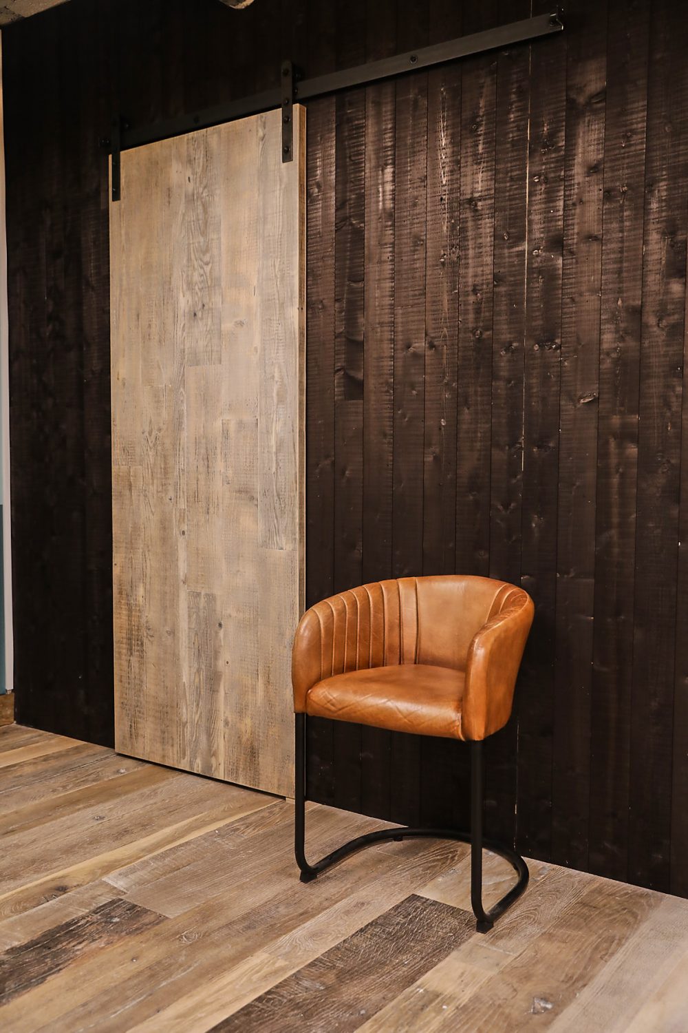 reclaimed whitewash sliding barn door against dark black wall cladding