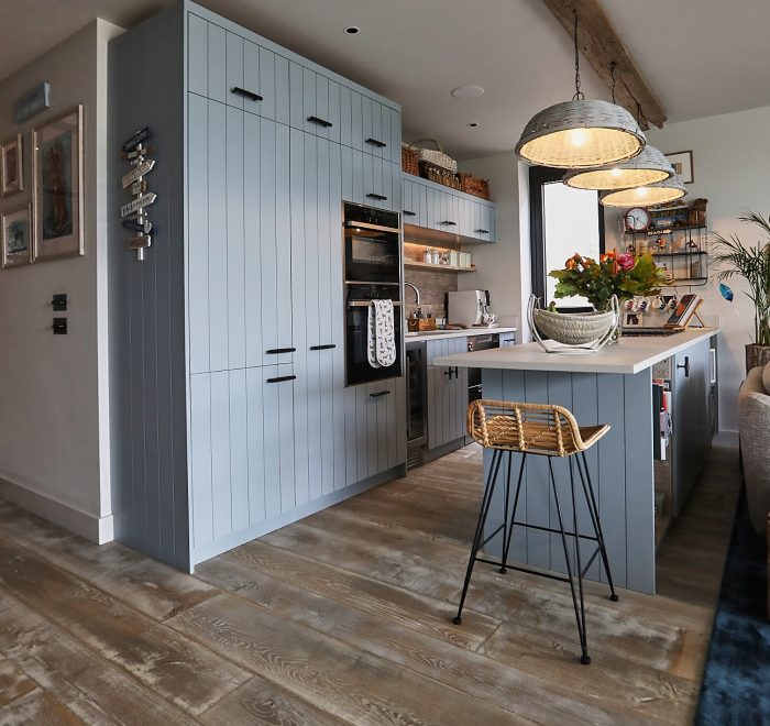 Baby blue bespoke kitchen with wooden flooring