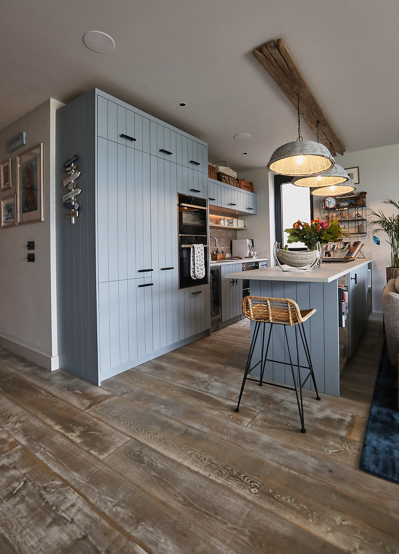 Baby blue bespoke kitchen with wooden flooring