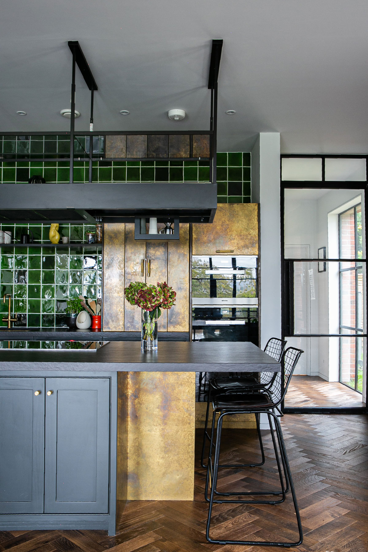 Aged brass kitchen island with falmec extraction above