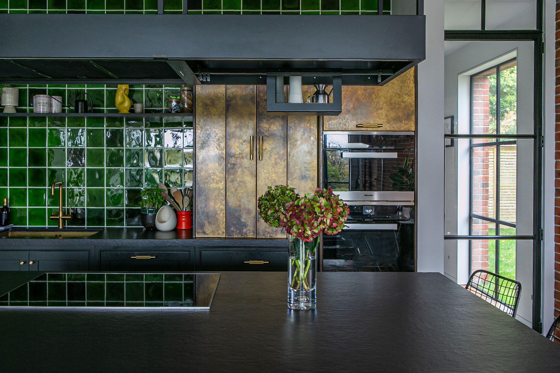 Aged brass and green tiles in bespoke kitchen