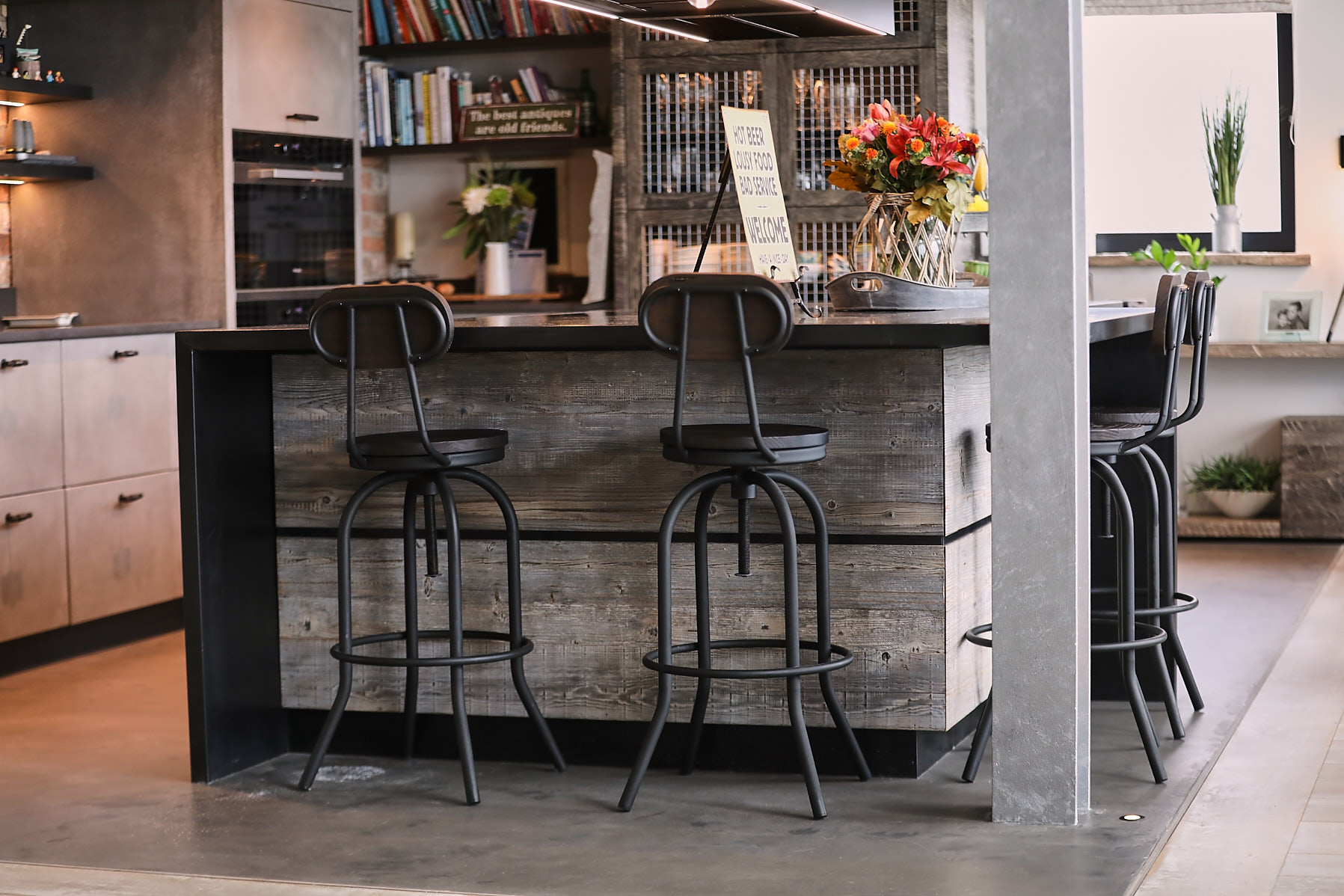Metal bar stools sit under zinc worktop on kitchen island