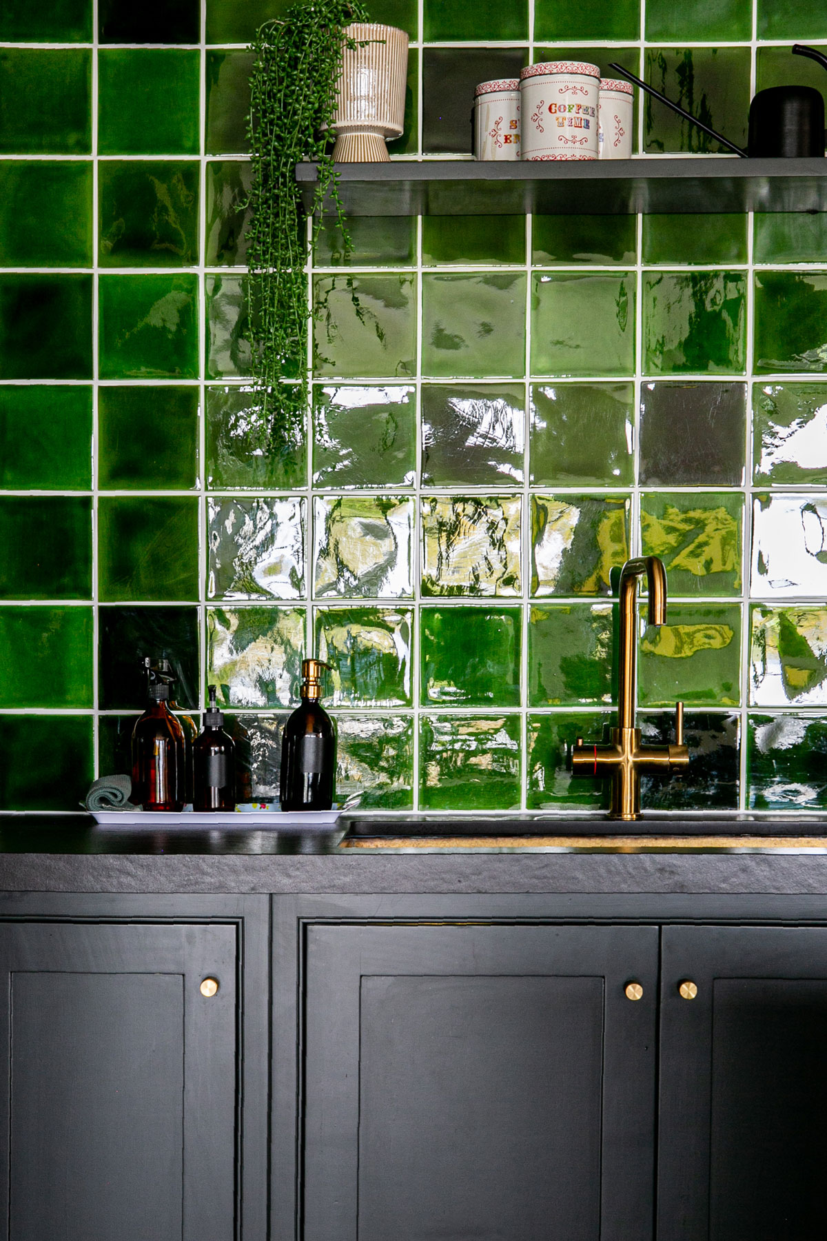 Kitchen cabinets painted in little greene lamp black with green tile back splash