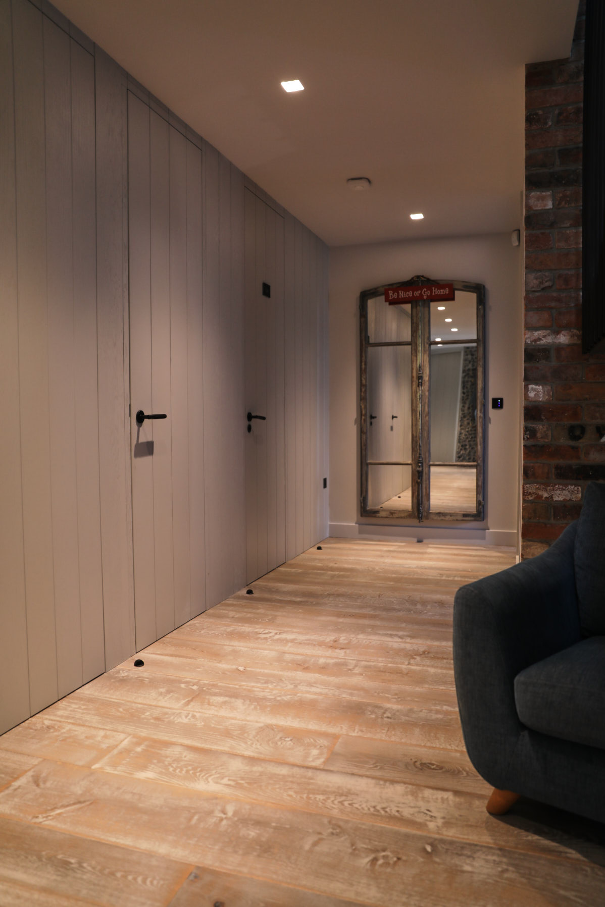 Reclaimed flooring in hallway with bespoke blue internal doors